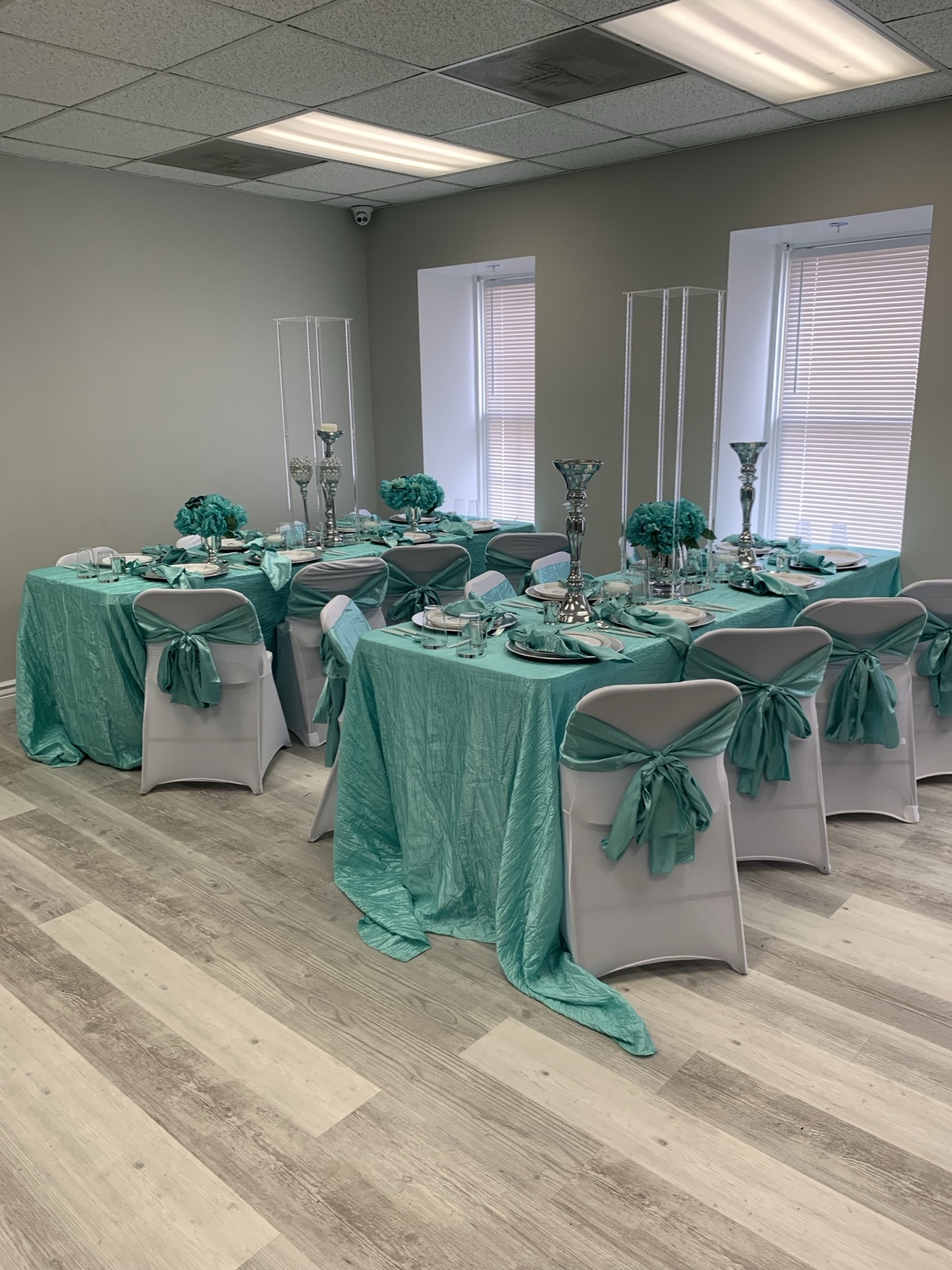 Round guest tables decorated with teal chair sashes