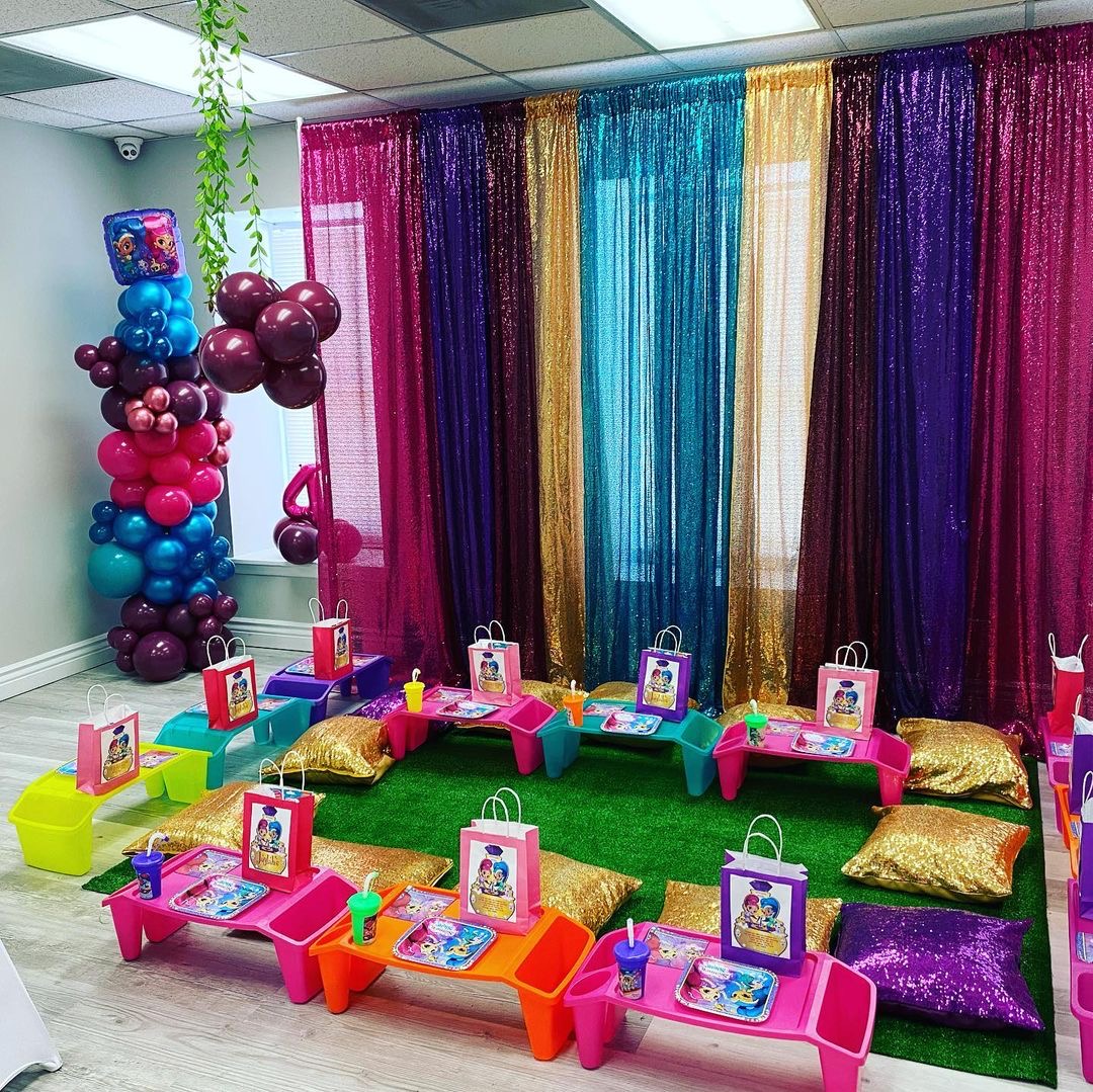 Colorful children’s party picnic table with rainbow fringe backdrop
