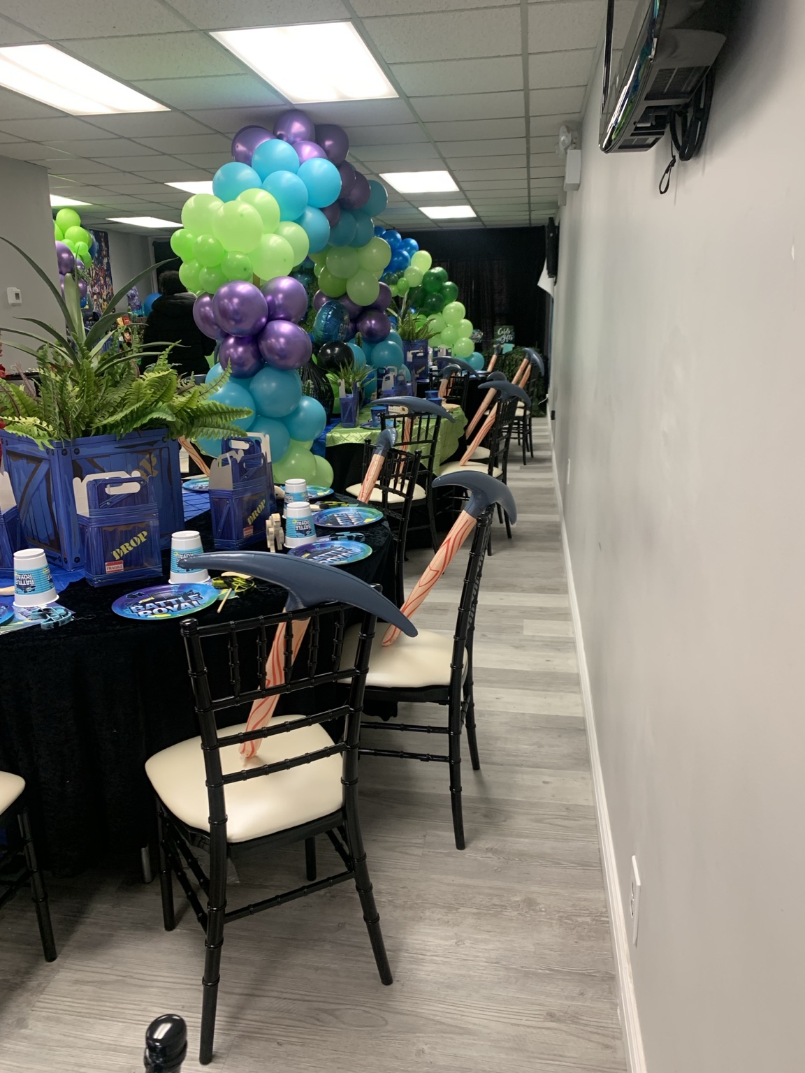 Birthday guest tables decorated with purple, blue, and green balloons