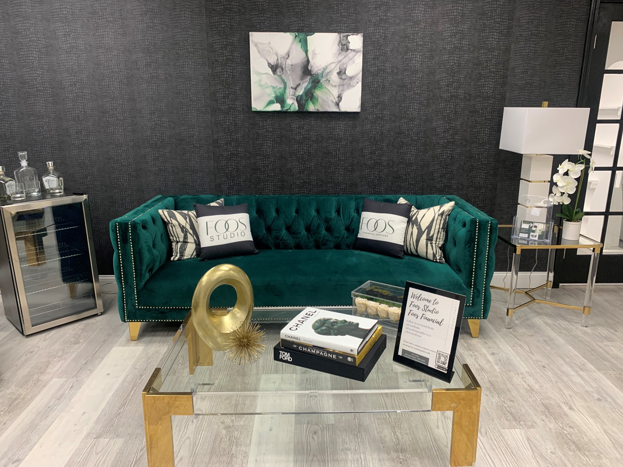 Foos Studio reception with a green velvet sofa and gold accents